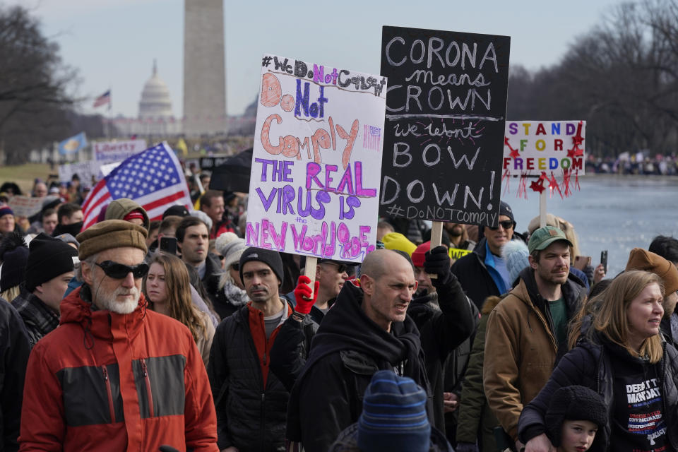 FILE - People march alongside the Lincoln Memorial Reflecting Pool before a rally against COVID-19 vaccine mandates, Jan. 23, 2022, in Washington. Republicans' faith in science is falling as Democrats rely on it even more with a trust gap in science and medicine widening substantially during the COVID-19 pandemic, new survey data shows. It’s the largest gap in nearly five decades of polling by the General Social Survey, a widely respected trend survey conducted by NORC at the University of Chicago that has been measuring confidence in institutions since 1972. (AP Photo/Patrick Semansky, File)