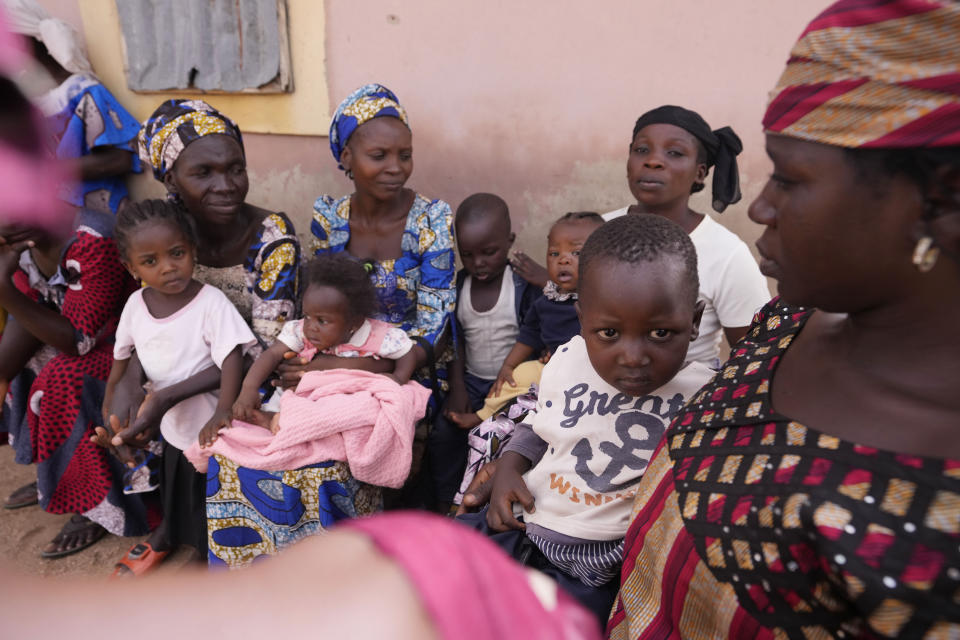 Women and their children wais during an event on how to prepare nutritious food in Kaltungo Poshereng Nigeria, Sunday, June 2, 2024. More than a dozen women gathered this week in Kaltungo's Poshereng village where they are learning at least 200 recipes they can prepare with those local foods which, in the absence of rain, are grown in sand-filled sacks that require small amounts of water. The training session mirrored the struggles of households who are more challenged amid Nigeria's worst cost of living crisis. (AP Photo/Sunday Alamba)