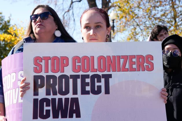 Demonstrators stand outside of the U.S. Supreme Court, as the court hears arguments over the Indian Child Welfare Act, on Nov. 9, 2022, in Washington. The Supreme Court is wrestling with a challenge to a federal law that gives preference to Native American families in foster care and adoption proceedings of Native children.