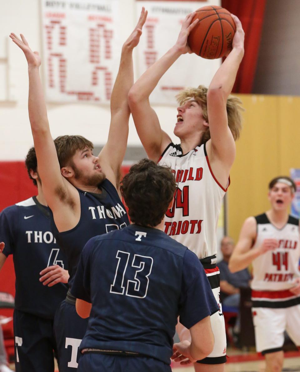 Penfield's Patrick Emling (34), pulls down an offensive board and goes back up over Thomas' Shane Talbot during their Section V boys basketball matchup Tuesday, Jan. 3, 2023 at Penfield High School.