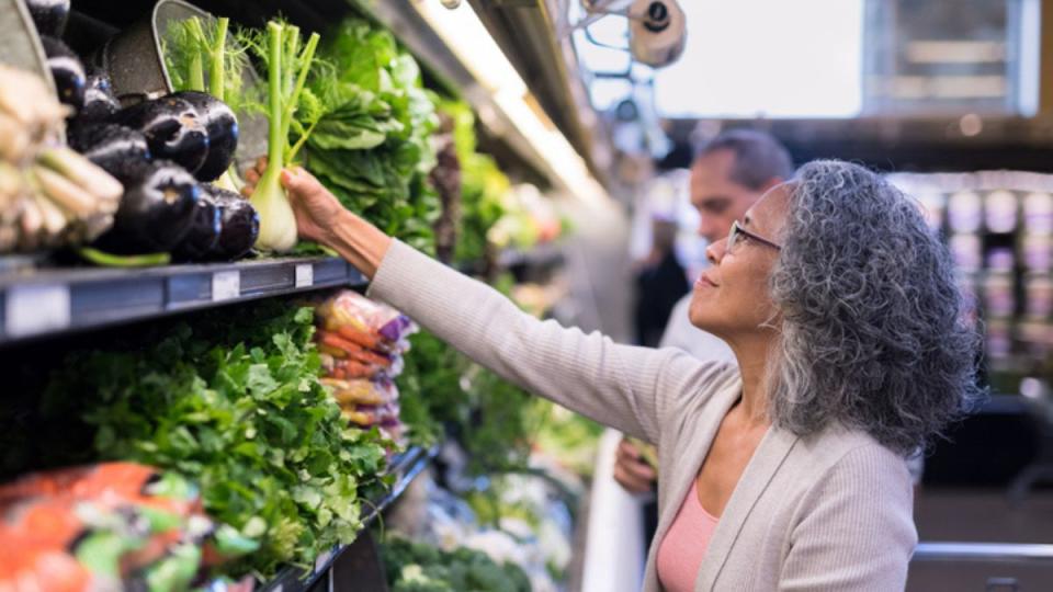 Mature woman following healthy eating hacks by grocery shopping for fresh produce on a full stomach