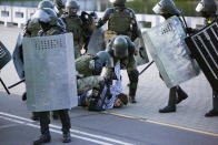 Riot police detain a protester during an opposition rally to protest the presidential inauguration in Minsk, Belarus, Wednesday, Sept. 23, 2020. Belarus President Alexander Lukashenko has been sworn in to his sixth term in office at an inaugural ceremony that was not announced in advance amid weeks of huge protests saying the authoritarian leader's reelection was rigged. Hundreds took to the streets in several cities in the evening to protest the inauguration. (AP Photo/TUT.by)