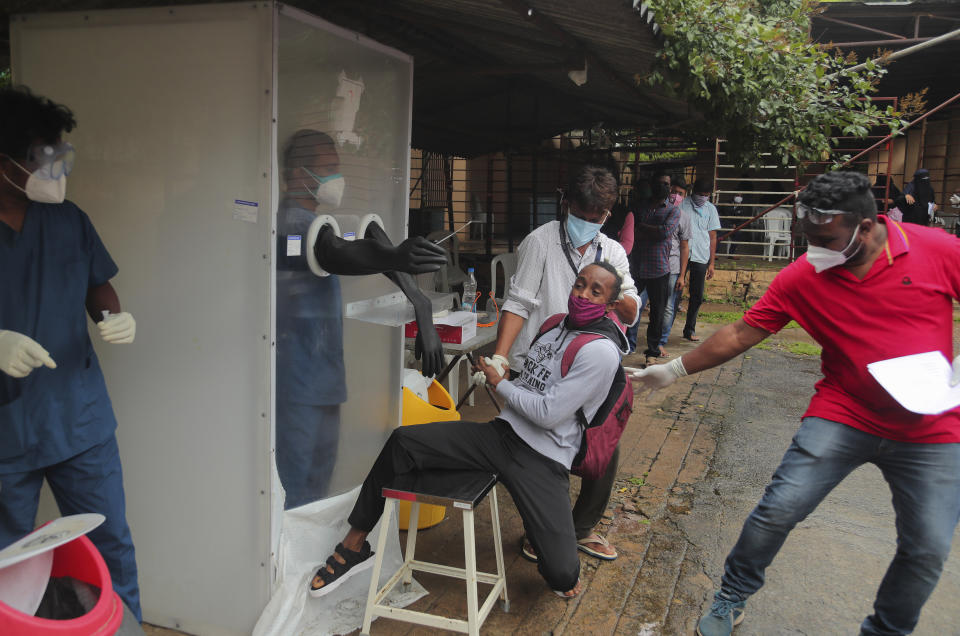 A man reacts as health workers help collect a nasal swab sample to test for COVID-19 in Hyderabad, India, Thursday, Sept. 17, 2020. As India’s coronavirus confirmed cases jump by a record 97,894 cases in the past 24 hours, Prime Minister Narendra Modi’s government faced a scathing opposition criticism in Parliament for its handling of the pandemic and a contracting economy leaving millions jobless on Thursday. (AP Photo/Mahesh Kumar A.)