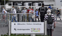 Workers with face masks enter the Toennies meatpacking plant, Europe's biggest slaughterhouse, where the German Bundeswehr army helps to build up a test center for coronavirus in Rheda-Wiedenbrueck, Germany, Friday, June 19, 2020. Hundreds of new COVID-19 cases are linked to a large meatpacking plant, officials ordered the closure of the slaughterhouse, as well as isolation and tests for everyone else who had worked at the Toennies site — putting about 7,000 people under quarantine. (AP Photo/Martin Meissner)