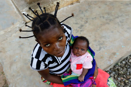 An internally displaced Congolese woman holds her child as they await post-natal care at the Kapangu maternity health centre in Kaniki-Kapangu near Mwene Ditu in Kasai Oriental Province in the Democratic Republic of Congo, March 15, 2018. Picture taken March 15, 2018. REUTERS/Thomas Mukoya