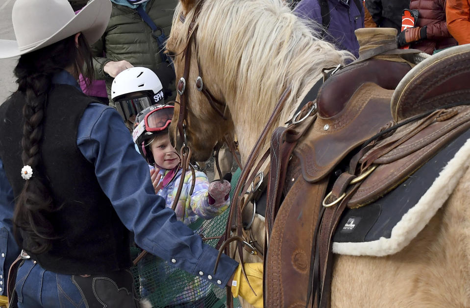 Kaja Ligeza pets a horse at a skijoring competition in Leadville, Colo., on Saturday, March 2, 2024. Skijoring draws its name from the Norwegian word skikjoring, meaning "ski driving." It started as a practical mode of transportation in Scandinavia and became popular in the Alps around 1900. Today's sport features horses at full gallop towing skiers by rope over jumps and around obstacles as they try to lance suspended hoops with a baton, typically a ski pole that's cut in half. (AP Photo/Thomas Peipert)
