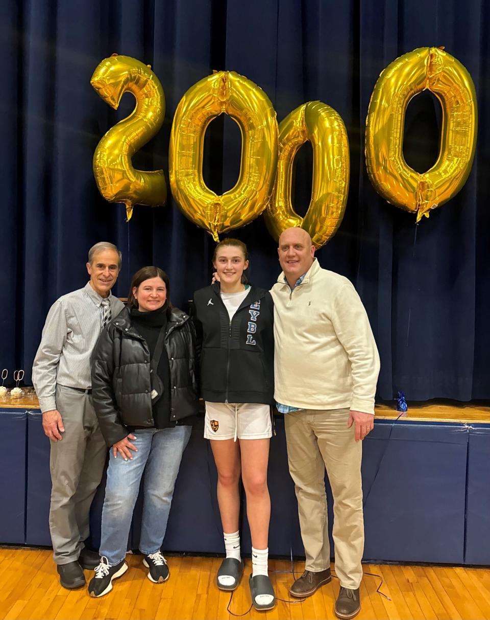 Lourdes' Simone Pelish poses with her parents and coach after scoring her 2,000th career point on Feb. 9, 2024. From left: Al Viani, Elizabeth Pelish, Simone and Adam Pelish.