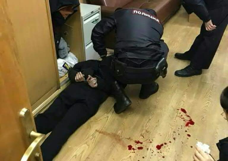 Picture obtained from Vitaly Ruvinsky's Facebook page on October 23, 2017 shows police officers detaining the man (L) who allegedly stabbed Tatiana Felgengauer, a presenter at Echo of Moscow radio station, in Moscow