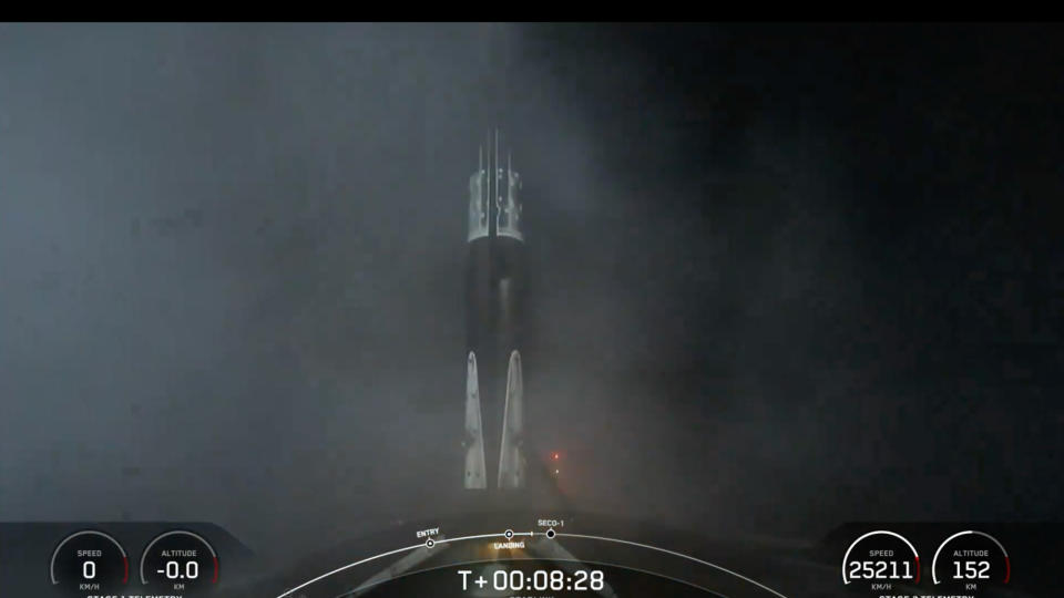 a black and white rocket sits on the deck of a ship at night