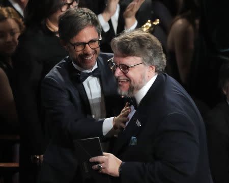 90th Academy Awards - Oscars Show - Hollywood, California, U.S., 04/03/2018 - Gael Garcia Bernal (L) congratulates Guillermo del Toro as he stands to accept the Oscar for Best Director for "The Shape of Water." REUTERS/Lucas Jackson