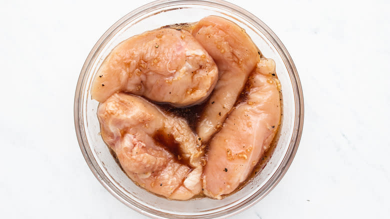 Chicken breasts and marinade in bowl