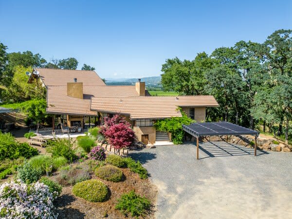 A wide gravel driveway leads to the sprawling 3,200-square-feet home, which sits nestled among soaring trees and manicured landscaping.