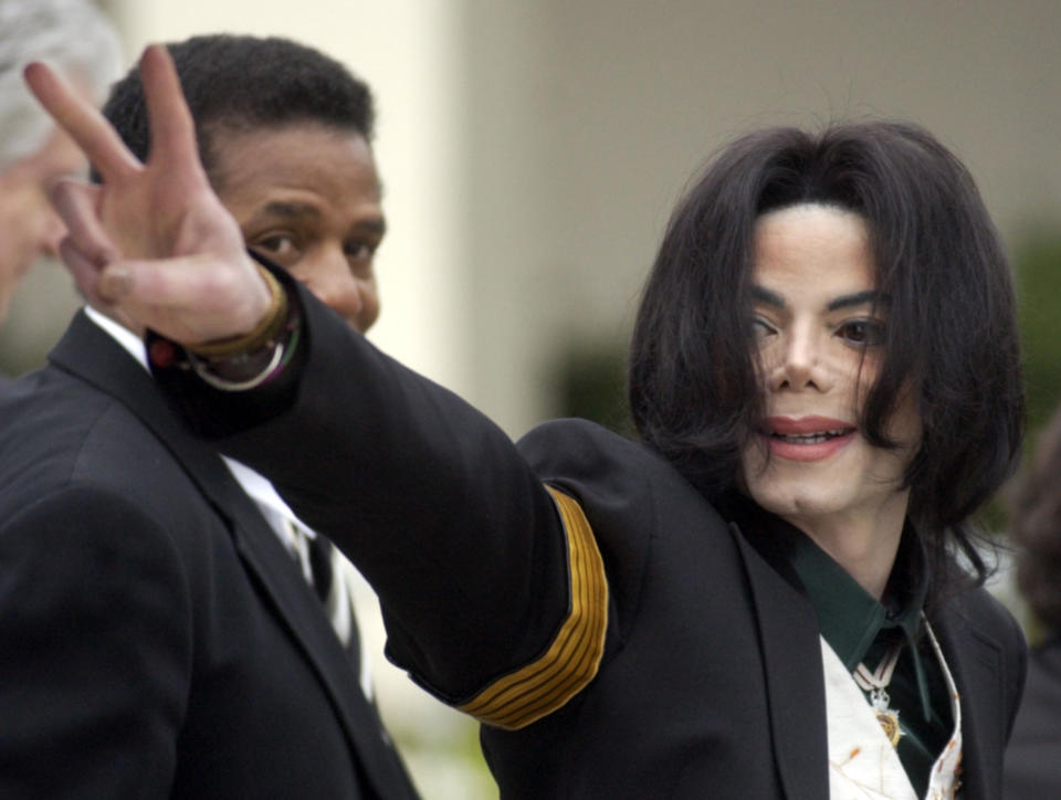 FILE - In this March 2, 2005 file photo, pop icon Michael Jackson waves to his supporters as he arrives for his child molestation trial at the Santa Barbara County Superior Court in Santa Maria, Calif. A new documentary premiering Sunday on HBO, "Leaving Neverland," is about the abuse allegations of two men, Wade Robson and James Safechuck, who had previously denied Jackson molested them and supported him to authorities and in Robson's case, very publicly. (AP Photo/Michael A. Mariant, File)