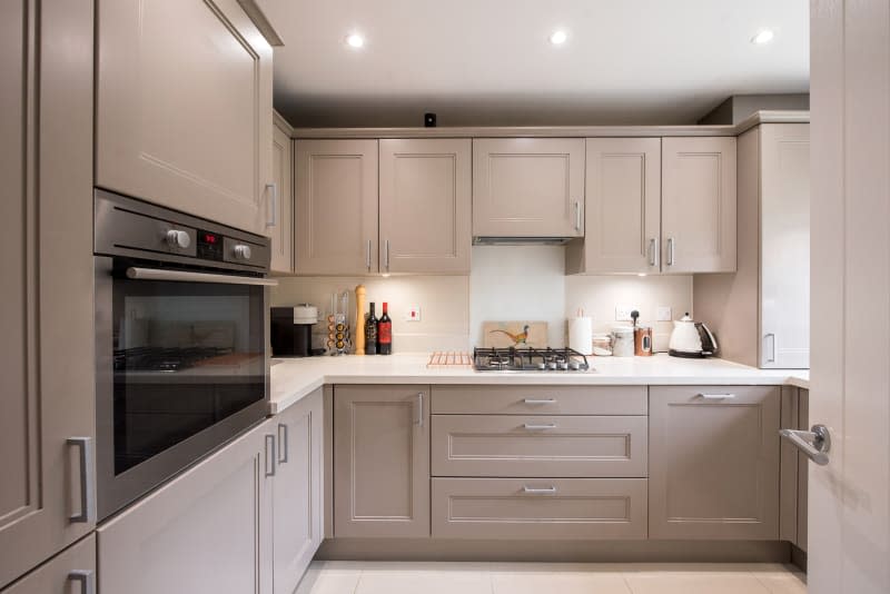 General interior view of a small truffle taupe colored shaker style kitchen in a home