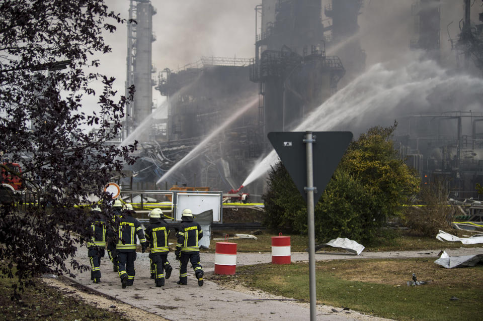 Firefighters walk over the area of a Bayernoil refinery in Vohburg an der Donau near Ingolstadt, southern Germany, Saturday, Sept. 1, 2018 after a fire broke out. (Lino Mirgeler/dpa via AP)