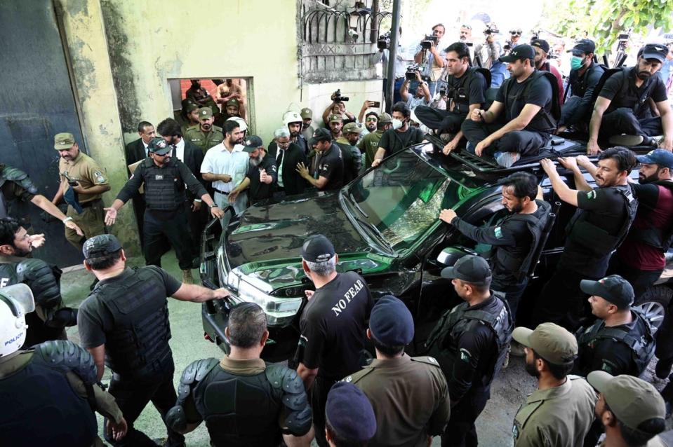 Private security members escort former Prime Minister Imran Khan (in vehicle) as he appears before a court to get extension in bails (EPA)