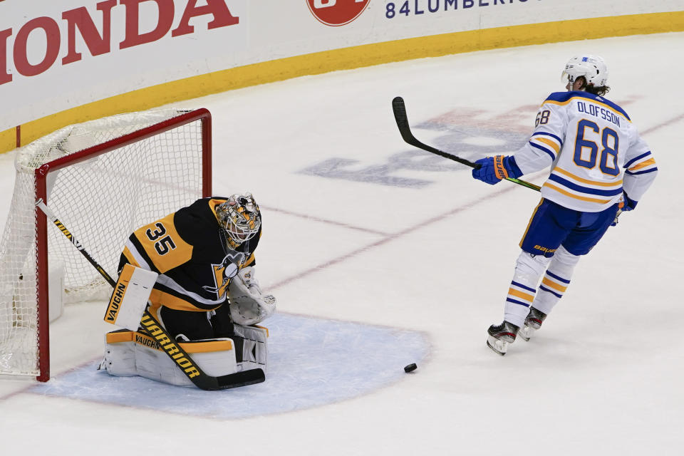 The puck bounces out of the net after Buffalo Sabres' Victor Olofsson (68) scored on a penalty shot on Pittsburgh Penguins goaltender Tristan Jarry (35) during the third period of an NHL hockey game, Wednesday, March 24, 2021, in Pittsburgh. Olofsson was awarded a penalty shot on the play and scored on that. The Penguins won 5-2. (AP Photo/Keith Srakocic)