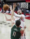 Portland Trail Blazers center Jusuf Nurkic, top, shoots over Milwaukee Bucks center Brook Lopez during the first half of an NBA basketball game in Portland, Ore., Friday, April 2, 2021. (AP Photo/Craig Mitchelldyer)