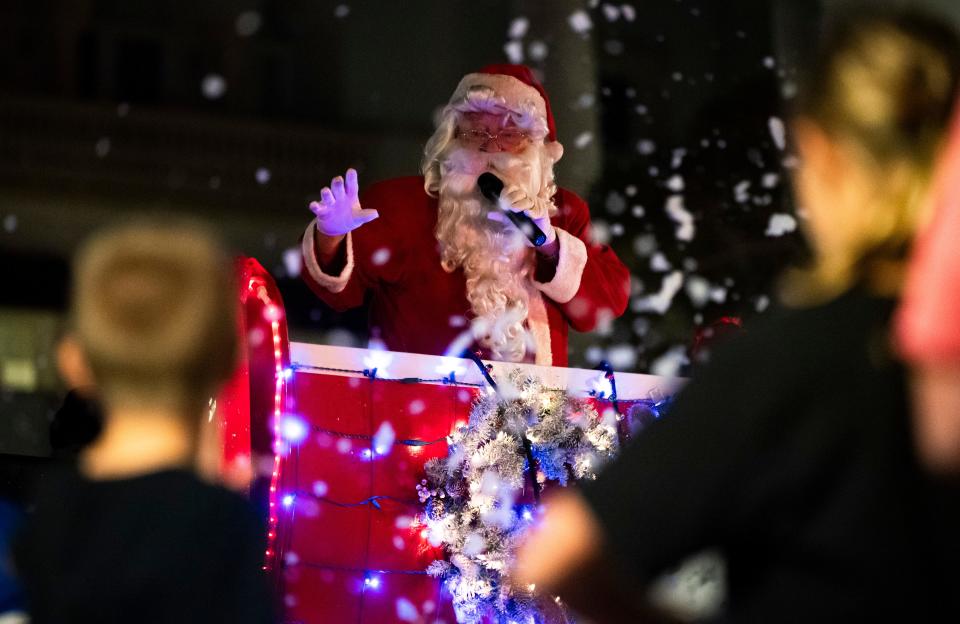 Santa waves to children during the Fifth Avenue South Christmas parade in Naples on Tuesday, Dec. 5, 2023.