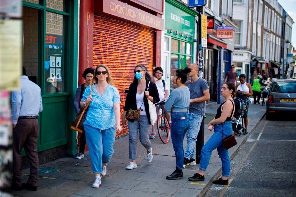 People queue outside a coffee shop in London: AFP via Getty Images