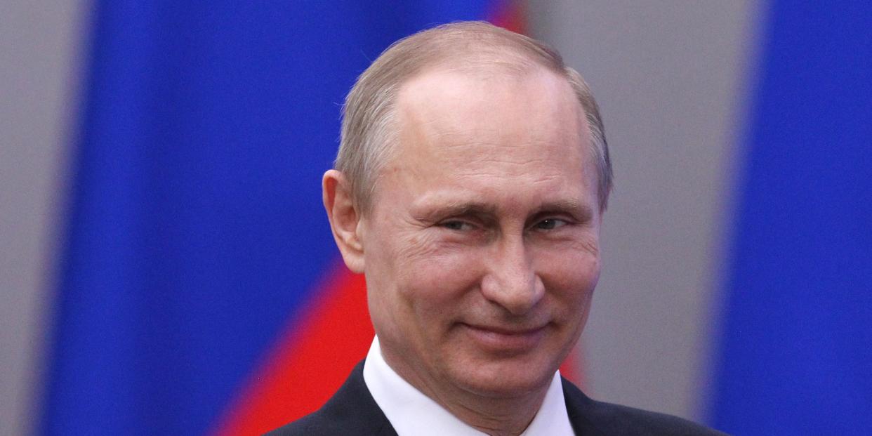 Vladimir Putin smiles.