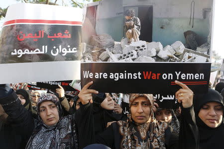 Women hold up banners as they take part in a protest against Saudi-led air strikes on Yemen, in front of the offices of the U.N. headquarters in Beirut May 12, 2015. REUTERS/Mohamed Azakir