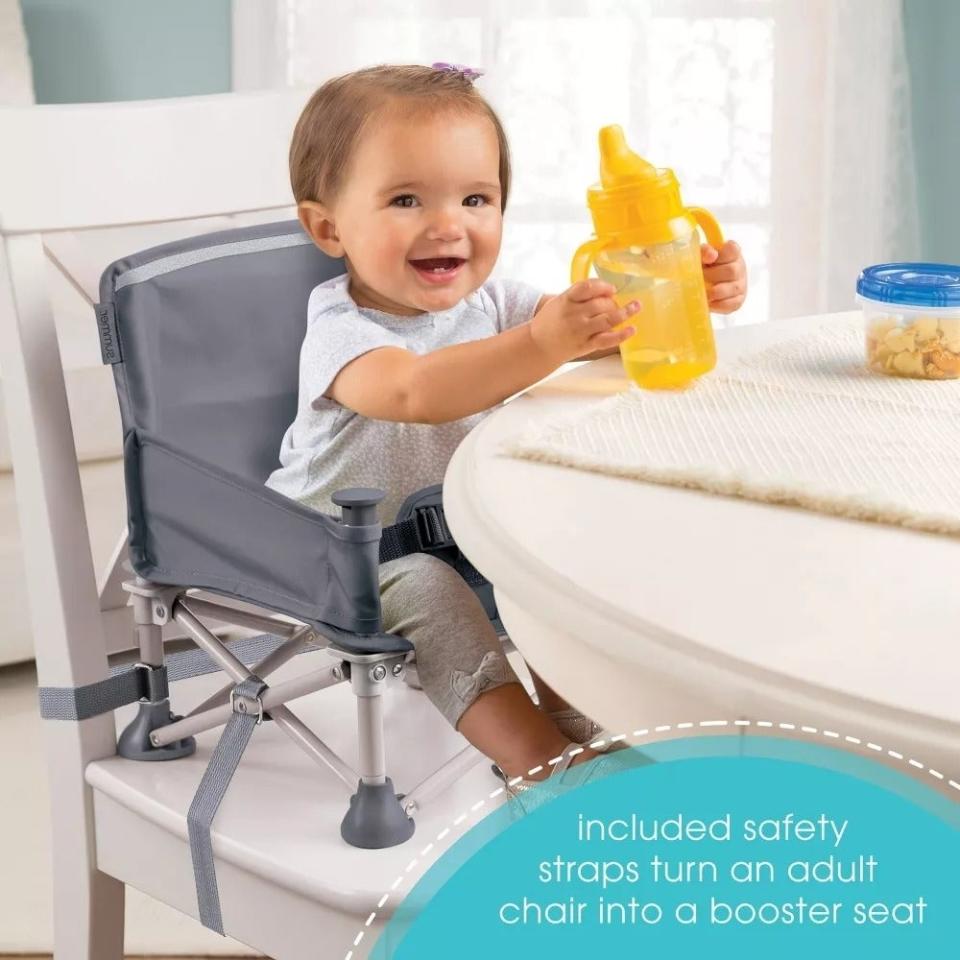 Toddler in portable booster seat at table with safety straps and yellow bottle