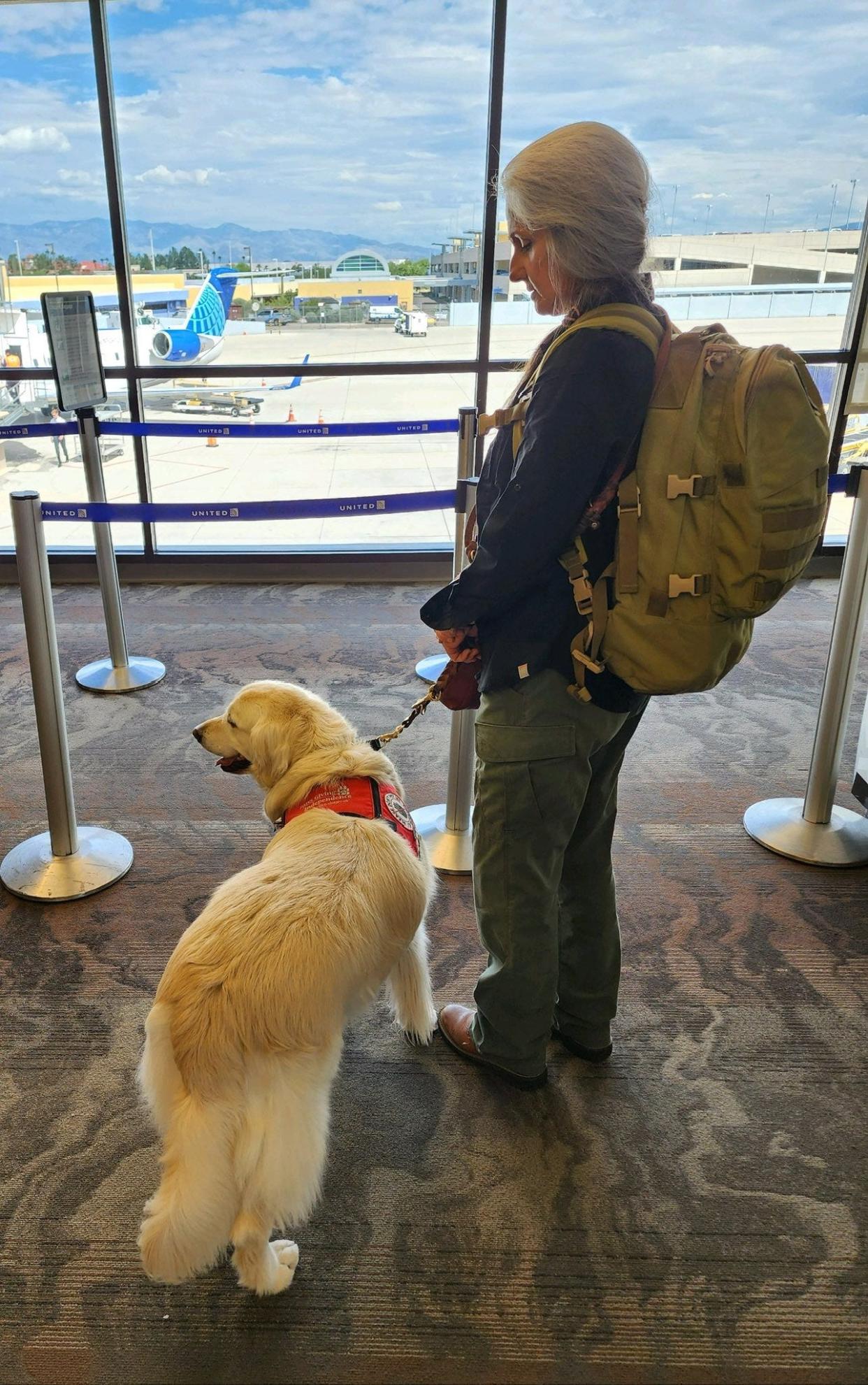 Joey Ramp-Adams and her service dog Sampson at an airport.