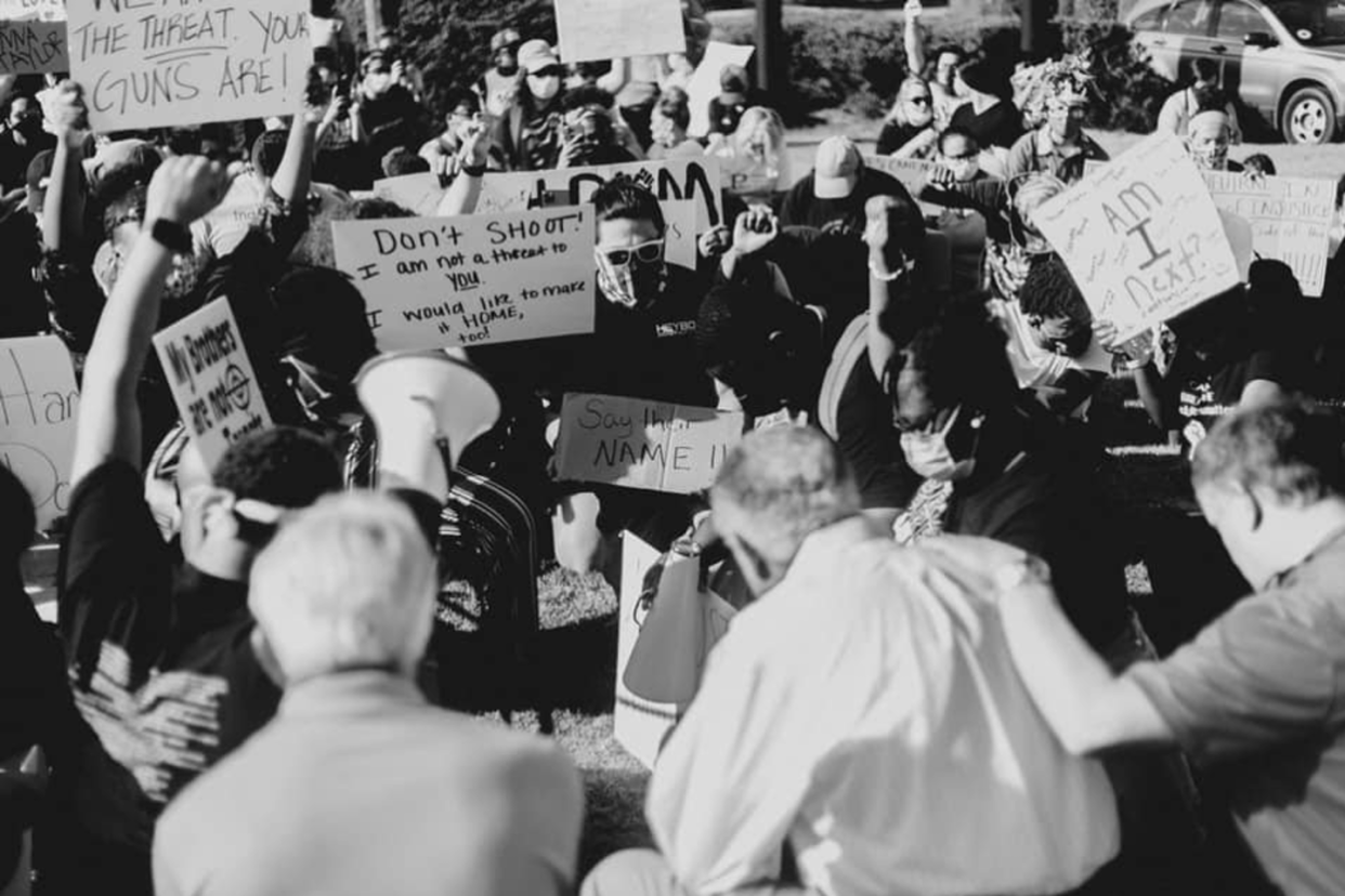 <span class="caption">Lumbee Reverend Dr. Mike Cummings, center with his back to the camera, prays for protesters in Pembroke, North Carolina.</span> <span class="attribution"><span class="source">Krista Davis</span>, <a class="link " href="http://creativecommons.org/licenses/by-nd/4.0/" rel="nofollow noopener" target="_blank" data-ylk="slk:CC BY-ND;elm:context_link;itc:0;sec:content-canvas">CC BY-ND</a></span>