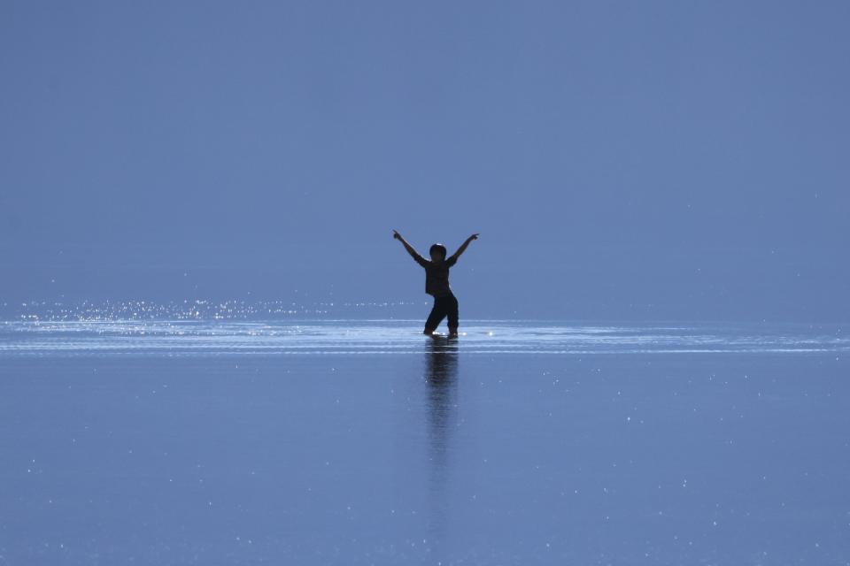 A tourist enjoys the rare opportunity to play knee deep in salty water as they visit Badwater Basin, the normally driest place in the US, in Death Valley National Park on Sunday.