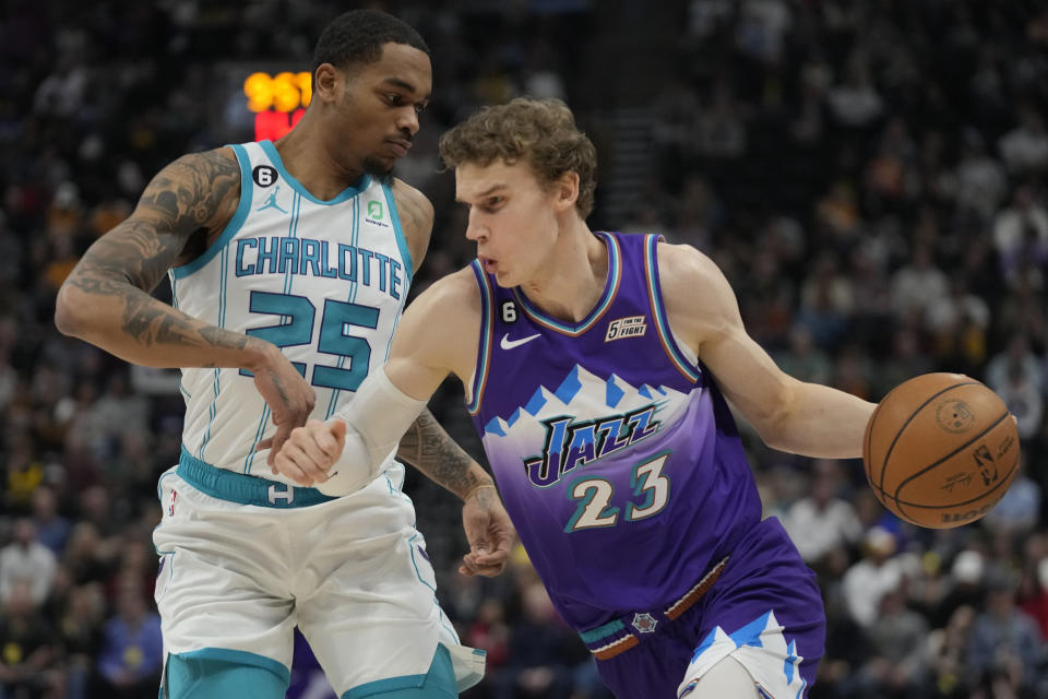 Utah Jazz forward Lauri Markkanen (23) drives around Charlotte Hornets forward P.J. Washington (25) during the first half of an NBA basketball game Monday, Jan. 23, 2023, in Salt Lake City. (AP Photo/Rick Bowmer)