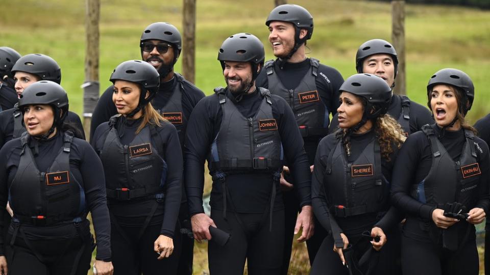 Mercedes “MJ” Javid, Larsa Pippen, Marcus Jordan, Johnny “Bananas” Devenanzio, Peter Weber, Shereé Whitfield, Kevin Kreider and Ekin-Su Cülcüloğlu standing outside preparing to compete in Peacock's The Traitors season 2