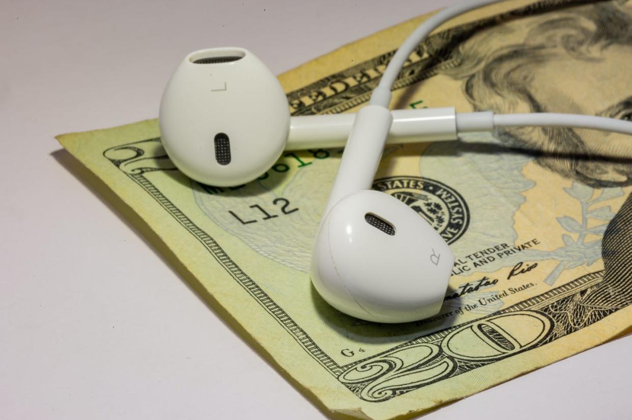 <span class="caption">Creators will now have the option to require a payment for audiences to access their content on Apple's platform.</span> <span class="attribution"><a class="link " href="https://www.gettyimages.com/detail/photo/ear-phones-on-top-of-money-symbolizing-that-you-can-royalty-free-image/1217461301?adppopup=true" rel="nofollow noopener" target="_blank" data-ylk="slk:Ramyr_Dukin/Getty Images;elm:context_link;itc:0;sec:content-canvas">Ramyr_Dukin/Getty Images</a></span>