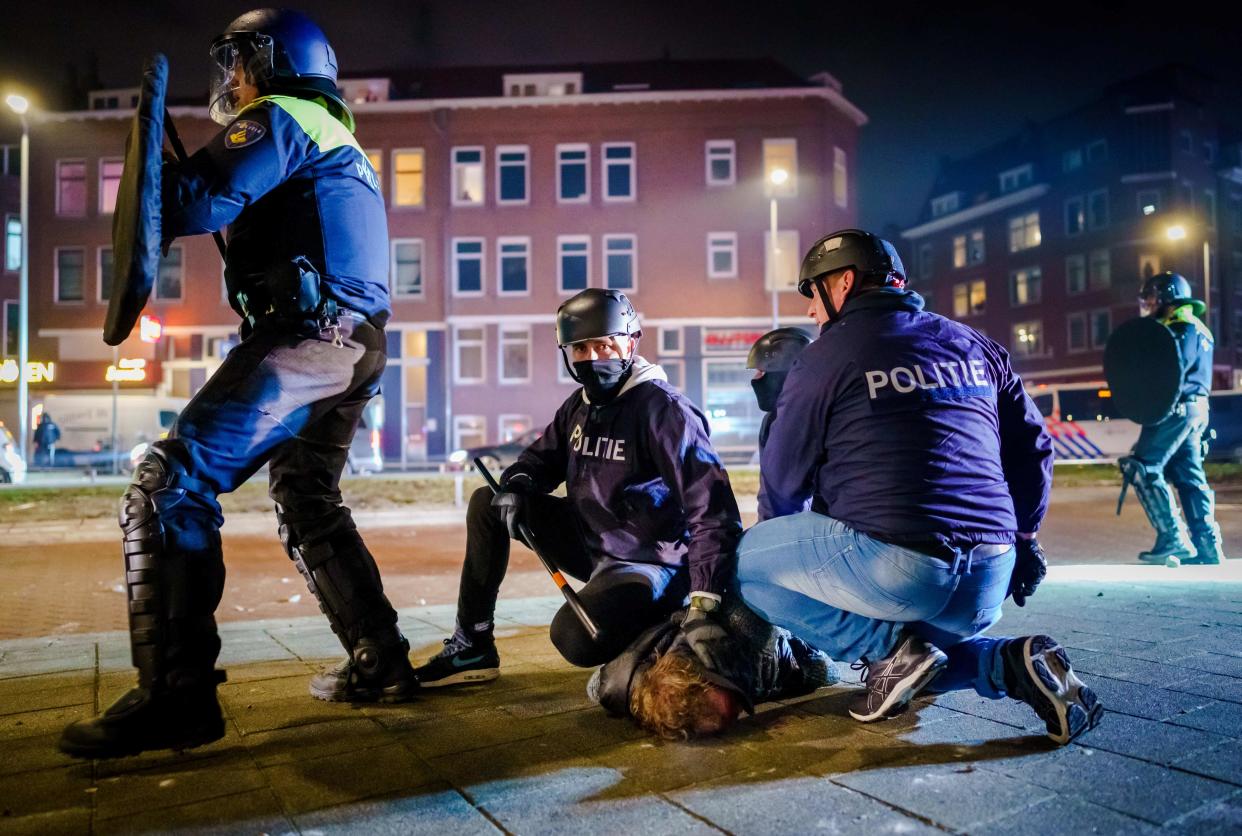 Dutch policemen arrest a man during clashes with a large group of young people on Beijerlandselaan in Rotterdam, on January 25 (ANP/AFP via Getty Images)