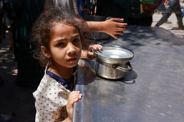 Displaced Palestinian children line up to receive food in Rafah on April 19, 2024.