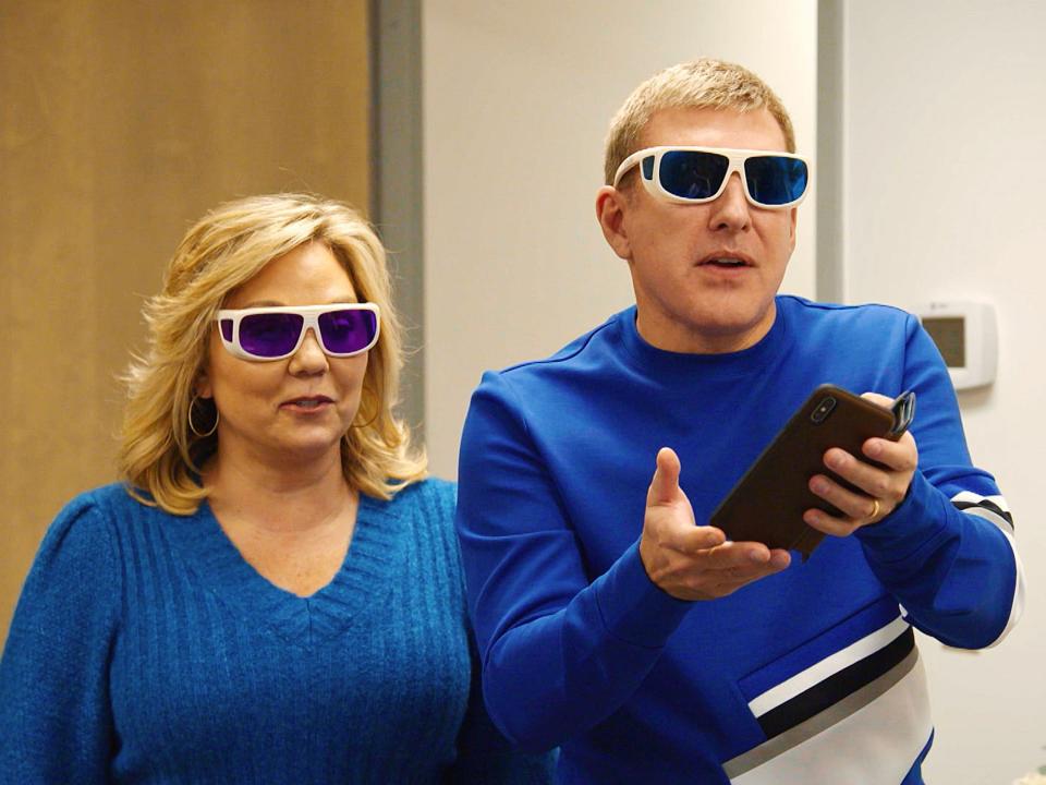 Todd and Julie Chrisley wear sunglasses and blue sweaters.