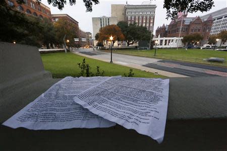 Papers left behind by a conspiracy supporter detailing conspiracy theories about U.S. President John F. Kennedy's 1963 assassination sit atop the "Grassy Knoll" in Dealey Plaza looking down on the spot where the president was shot in Dallas, November 21, 2013. REUTERS/Jim Bourg