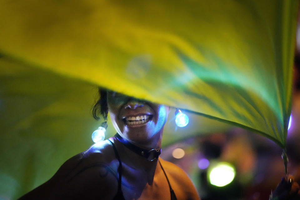 A woman performs with flags during a protest to commemorate International Women's Day, in Asuncion, Paraguay, on March 8, 2022. (AP Photo/Jorge Saenz)