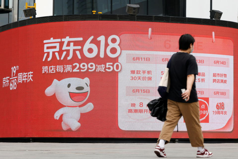A resident, wearing a face mask following the coronavirus disease (COVID-19) outbreak, walks past a JD.com advertisement for the 