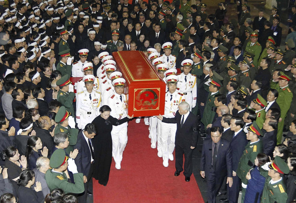 Vietnam's Communist Party General Secretary Nguyen Phu Trong, front right, Chairwoman of the National Assembly Nguyen Thi Kim Ngan, front left, and an honor guard carry the coffin of the late President Tran Dai Quang in Hanoi, Vietnam, Thursday, Sept. 27, 2018. Thousands of people lined the streets of Hanoi on Thursday to pay their last respects to the late president. Quang died on Sept. 21 at age 61. (Nguyen Van Diep/Vietnam News Agency via AP)