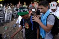 Migrants are seen in front of security forces near Frontera Hidalgo