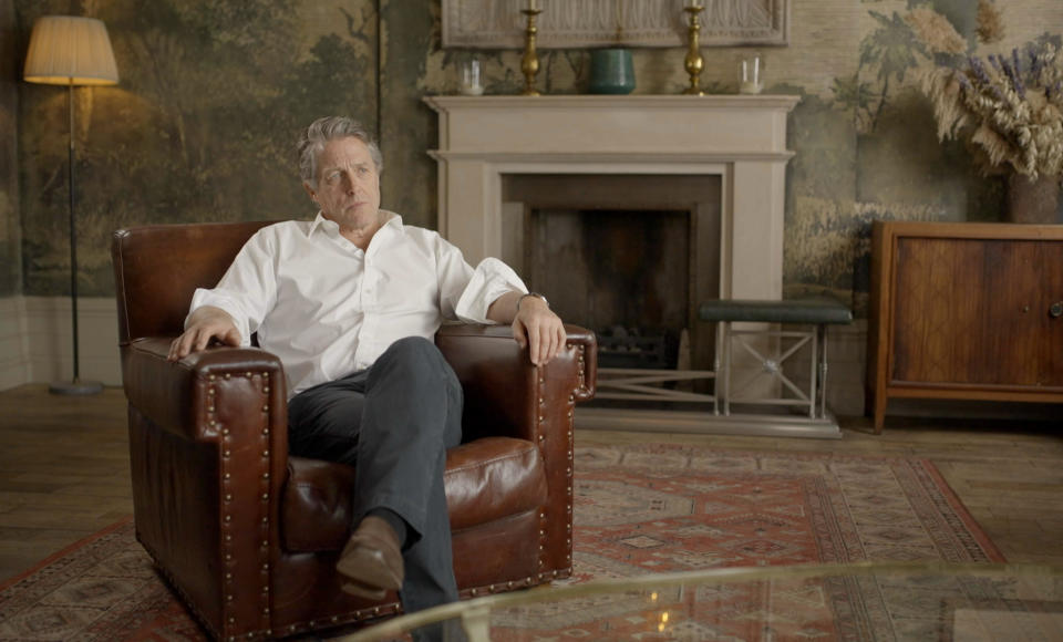 Hugh Grant sits in a leather arm chair while being interviewed for the programme