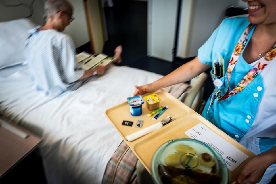 <span>Une aide-soignante sert un plateau-repas à une personne atteinte de cancer à l'institut Léon Bérard à Lyon le 10 septembre 2018</span><div><span>JEAN-PHILIPPE KSIAZEK</span><span>AFP</span></div>