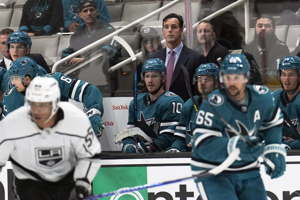 San Jose Sharks head coach David Quinn watches while standing behind his players on the bench during the third period against the Los Angeles Kings in a preseason NHL hockey game in San Jose, Calif., Sunday Sept. 25, 2022. San Jose won 3-2 in overtime. (AP Photo/Tony Avelar)