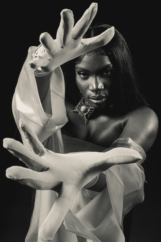 A woman holds her hands out to the camera for a photograph