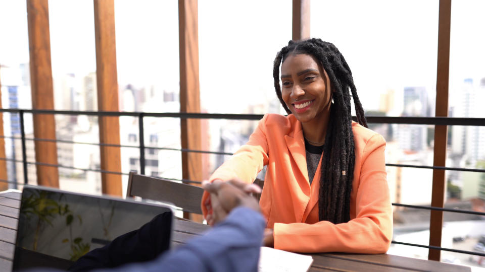 Businesswoman shaking hands with businessman during meeting on rooftop