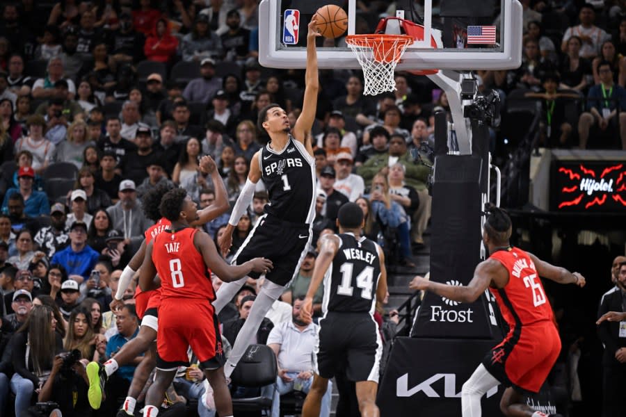 San Antonio Spurs’ Victor Wembanyama (1) dunks during the second half of an NBA basketball game against the Houston Rockets, Tuesday, March 12, 2024, in San Antonio. Houston won 103-101. (AP Photo/Darren Abate)