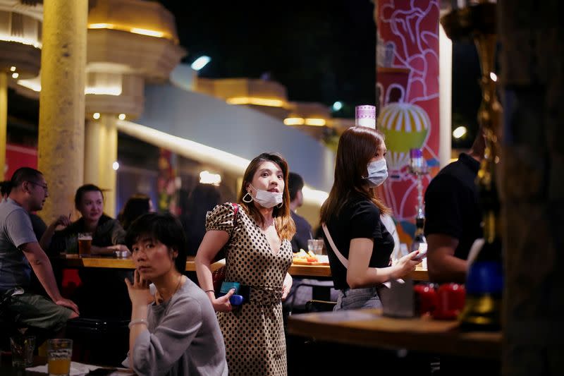 People wearing face masks are seen at a bar area in a nightclub after it reopens in Shanghai