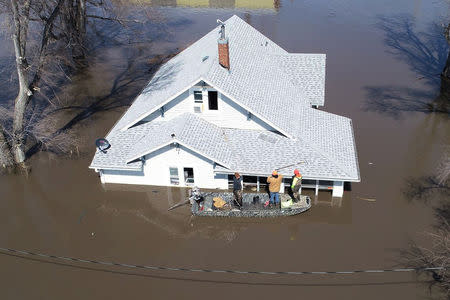 Lanni Bailey and a team from Muddy Paws Second Chance Rescue enter a flooded house to pull out several cats during the flooding of the Missouri River near Glenwood, Iowa, U.S. March 18, 2019. Passport Aerial Photography/Handout via REUTERS.