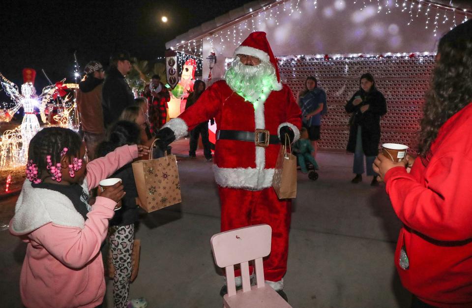 Frank Perales, dressed as Santa, hands out gifts Friday during a Christmas celebration at a home on Hidalgo Street in Desert Hot Springs.